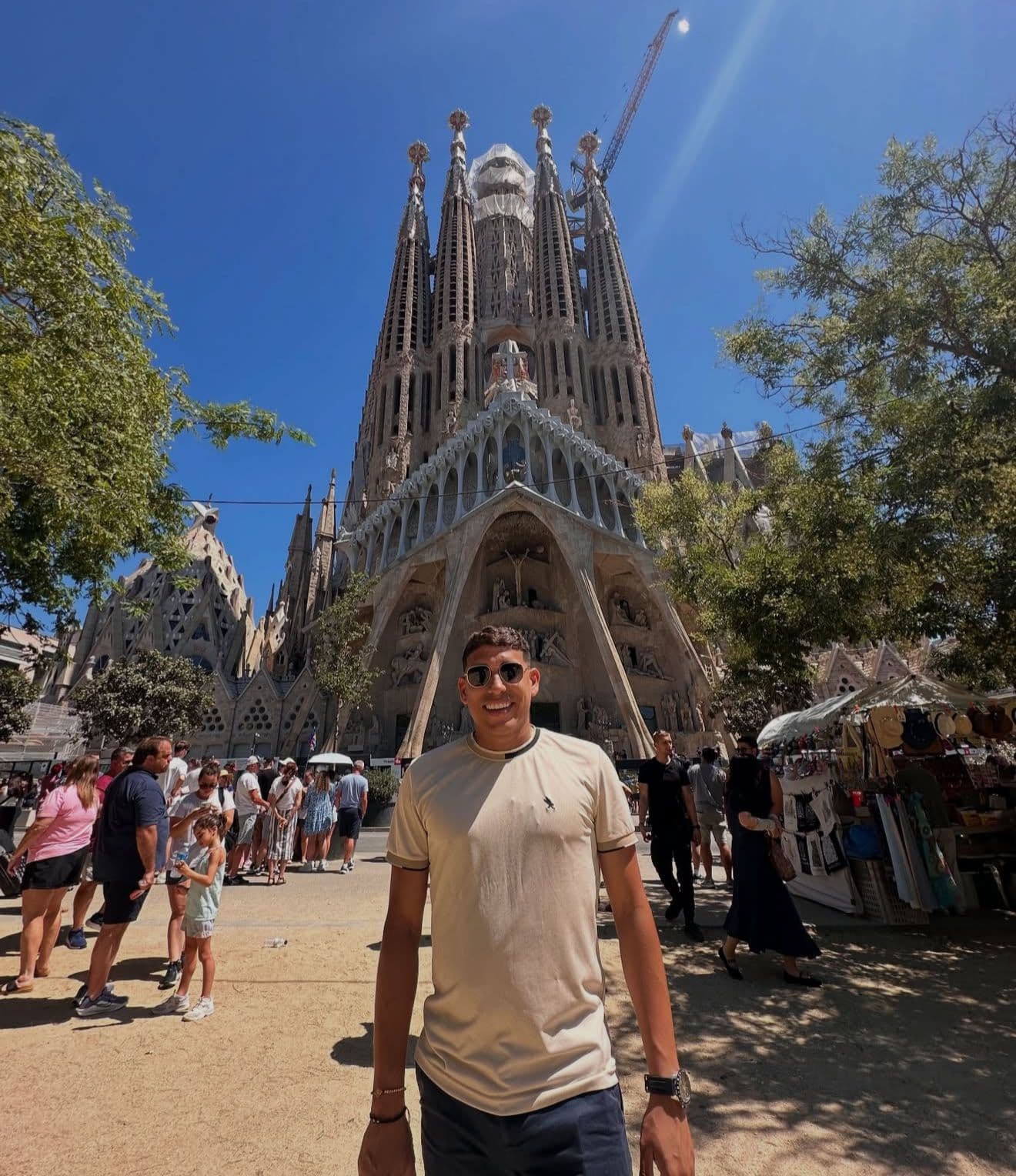 Hombre con gafas de sol posa frente a la Sagrada Familia en Barcelona, España.